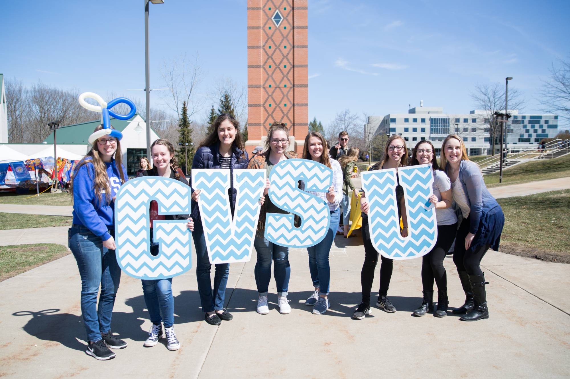 8 GVSU students holding a letters that spell "GVSU" at Lakerpalooza